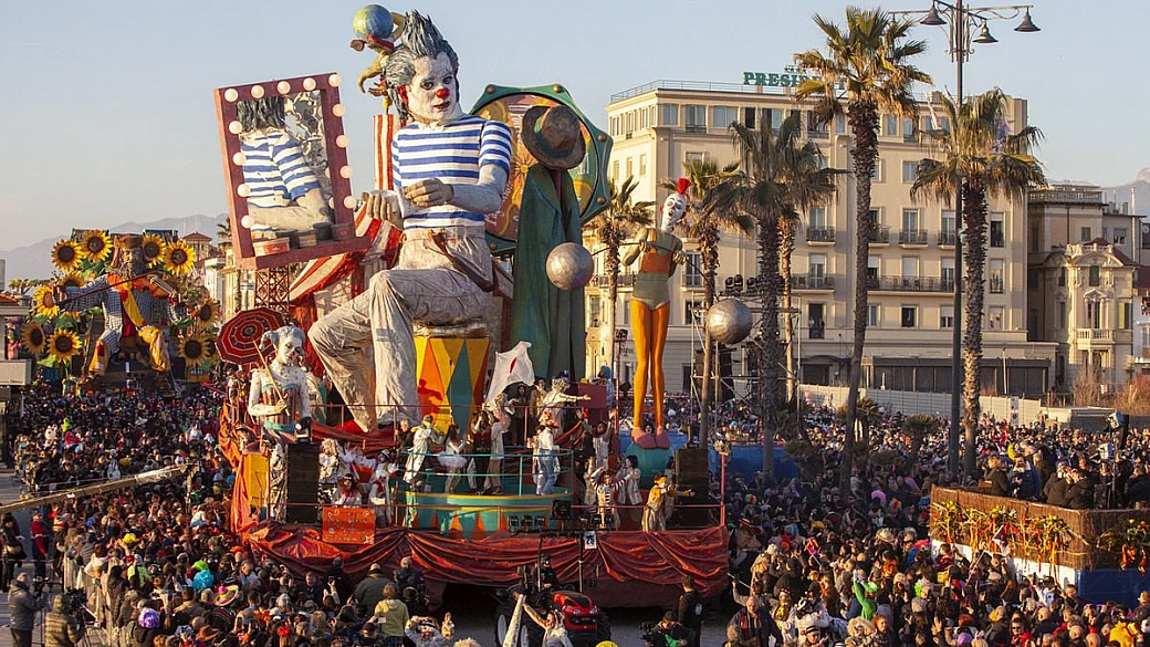 Imponente gigante di cartapesta di un carro allegorico tra la folla sul Viale a Mare durante il Carnevale di Viareggio