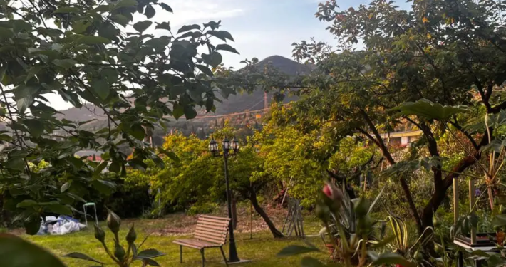 Romantisch beleuchteter Gartengarten der Locanda 213 im Hinterland der Versilia mit gedeckten Tischen unter Lichterketten am Abend